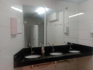 a bathroom with three sinks and a large mirror at Agencia e Pousada - Capitolio - MG in Capitólio