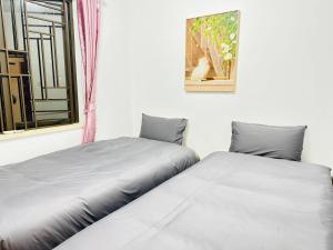 Duas camas num quarto com uma janela em Homeboy享家-轻奢民宿 em Shenzhen