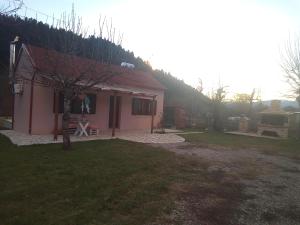 a small pink house with a tree in the yard at Villa Gianna in Karpenisi