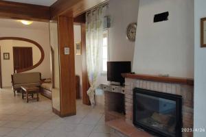 uma sala de estar com lareira e televisão em La casa vacanza di Jano em Francavilla di Sicilia