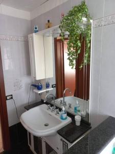 uma casa de banho com um lavatório e um espelho em La casa vacanza di Jano em Francavilla di Sicilia