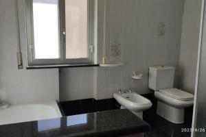 uma casa de banho branca com um WC e um lavatório em La casa vacanza di Jano em Francavilla di Sicilia