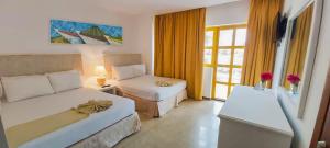 Habitación de hotel con 2 camas y ventana en Sunsol Ecoland en Pedro Gonzalez