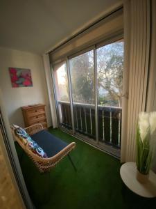 a room with a chair and a large window at Studio La Baleine Rose Centre Cap D'Agde in Cap d'Agde
