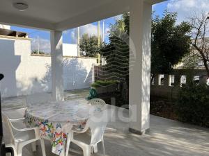 a table and chairs sitting on a porch with a table and a table and chairs at Villa Nah - Spiaggia a 250m in Torre Lapillo