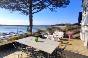 a picnic table with chairs and an apple on it at Maison/Appart de standing vue mer in Guidel