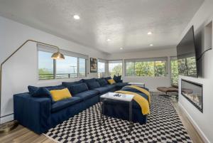 ein Wohnzimmer mit einem blauen Sofa und gelben Kissen in der Unterkunft Renovated 3BD 2BA Escape w Hot Tub and City Views in Salt Lake City