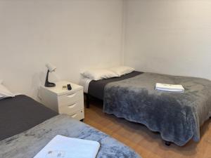 a bedroom with two beds and a night stand with a lamp at Peters Guesthouse in Aveiro