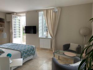 ein Schlafzimmer mit einem Bett und ein Wohnzimmer in der Unterkunft EN VILLE à LA CAMPAGNE 2 in Louhans