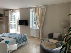 a bedroom with a bed and a living room at EN VILLE à LA CAMPAGNE 2 in Louhans