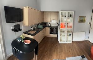 a small kitchen with a table and a refrigerator at Edinburgh TWO BEDROOM apartment with free side street parking 24 hours in Edinburgh