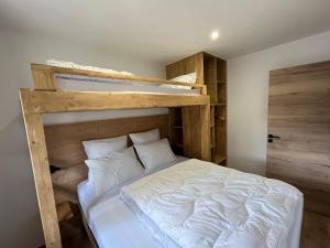 1 dormitorio con litera con sábanas y almohadas blancas en CHALET DE CHARME LE GOLEON - 3 Chambres - VALLOIRE CENTRE en Valloire