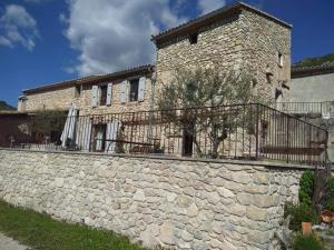 a building with a stone wall and a fence at FONT DE RAINE in Rottier