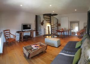 a living room with a couch and a spiral staircase at FONT DE RAINE in Rottier