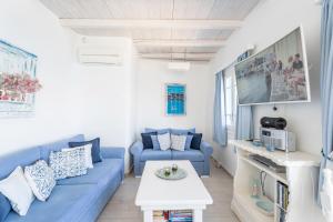 a living room with a blue couch and a table at Luxury Sea House By Blue Waters Mykonos in Ornos
