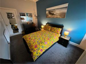 a bedroom with a bed and a painting on the wall at Edinburgh TWO BEDROOM apartment with free side street parking 24 hours in Edinburgh