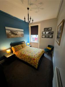 um quarto com uma cama com um edredão colorido e uma janela em Edinburgh TWO BEDROOM apartment with free side street parking 24 hours em Edimburgo