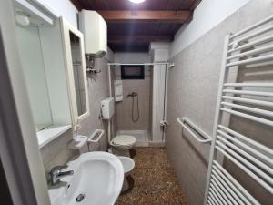 een badkamer met een toilet, een wastafel en een douche bij Appartamento Porto Cesareo in Porto Cesareo