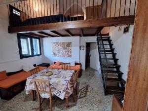 uma sala de jantar com uma mesa e uma escada em espiral em Appartamento Porto Cesareo em Porto Cesareo