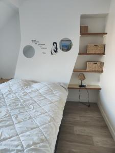 um quarto com uma cama com uma placa na parede em Cosy, central et convivial em Trouville-sur-Mer