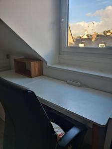 um quarto com uma secretária, uma cadeira e uma janela em Cosy, central et convivial em Trouville-sur-Mer