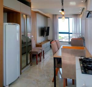 a kitchen and living room with a white refrigerator at 150m da praia em um fantástico edifício em Balneário Piçarras in Piçarras