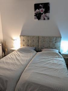 a bed in a bedroom with a picture on the wall at À 7 minutes de l'aéroport CDG 1 in Thieux