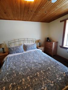 - une chambre avec un grand lit et un plafond en bois dans l'établissement Auberge Schweizer, à Sutton