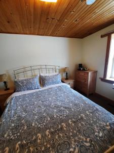 a bedroom with a large bed with a wooden ceiling at Auberge Schweizer in Sutton