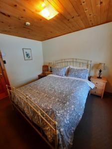 een bed in een slaapkamer met een houten plafond bij Auberge Schweizer in Sutton