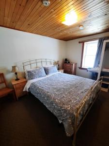 een slaapkamer met een bed en een houten plafond bij Auberge Schweizer in Sutton