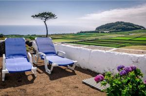 2 chaises bleues assises au-dessus d'un mur dans l'établissement Casa do Miradouro, à Santa Bárbara 7 autres photos