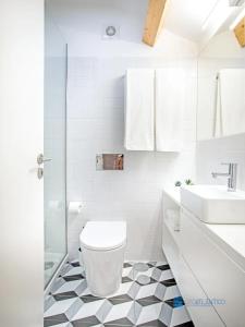 La salle de bains blanche est pourvue de toilettes et d'un lavabo. dans l'établissement Porto Cedofeita Art & Design Loft, à Porto