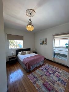 a bedroom with a bed and a chandelier at Hotel Boutique & Spa Puerto Natura in Valparaíso