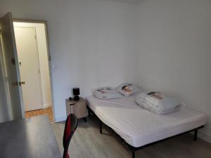 昂古萊姆的住宿－Chambre dans meublé tout équipé，客房设有一张带白色床单和一张桌子的床。