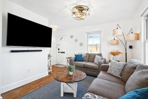 ein Wohnzimmer mit einem Sofa und einem Flachbild-TV in der Unterkunft Logan's House in Frederick