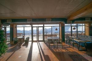 a room with tables and chairs and a view of the mountains at Chalet Papa Basili in Gudauri +89 photos