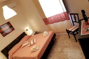 - une chambre avec un lit et 2 serviettes dans l'établissement CASA SINGOLA ALLE PORTE DEL SINIS, à Baratili San Pietro