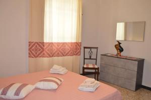 - une chambre avec un lit, une commode et un miroir dans l'établissement CASA SINGOLA ALLE PORTE DEL SINIS, à Baratili San Pietro
