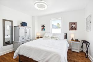 ein weißes Schlafzimmer mit einem Bett und einem Spiegel in der Unterkunft Logan's House in Frederick