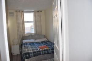 a small bedroom with a bed and a window at Four Bedroom House Chandos Road in London