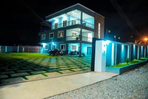 a house with blue lights on the side of it at Ayan Villas in Accra