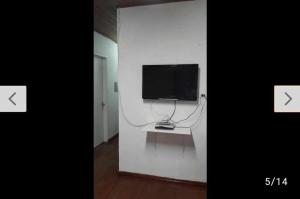a room with a tv on a white wall at Casa para 12 pessoas in Piratuba