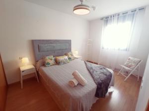 sypialnia z łóżkiem z dwoma ręcznikami w obiekcie Apartamento con Aire Acondicionado, Piscina, Wifi y Smart TV - by Aloha Palma w mieście Águilas