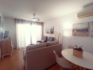 a living room with a couch and a table at Apartamento con Aire Acondicionado, Piscina, Wifi y Smart TV - by Aloha Palma in Águilas