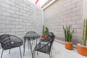 a patio with three chairs and a table and some plants at Comfort apartments Doctor Neva by VH in Mexico City