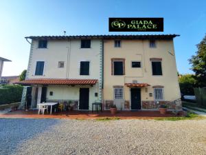 a large white building with a sign for a pizza palace at Giada Palace Group - Sweet City Center Apartment in Lucca