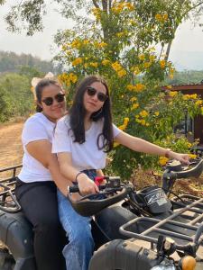 two women are riding on a motorcycle at Doi Sang Farm Stay - ดอยซางฟาร์มสเตย์ in Ban Huai Kom