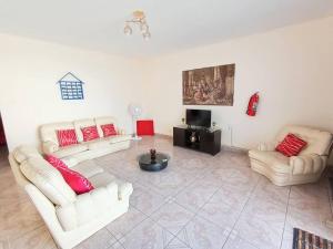 ein Wohnzimmer mit zwei weißen Sofas und roten Kissen in der Unterkunft Equipada, Amplia, 5 min de la Playa in Pacasmayo