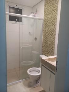 a bathroom with a toilet and a glass shower at Apartamento próximo ao centro com elevador! in Patos de Minas